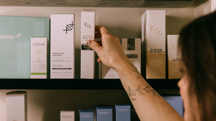 Person selecting a skincare product from a shelf with various skincare boxes.